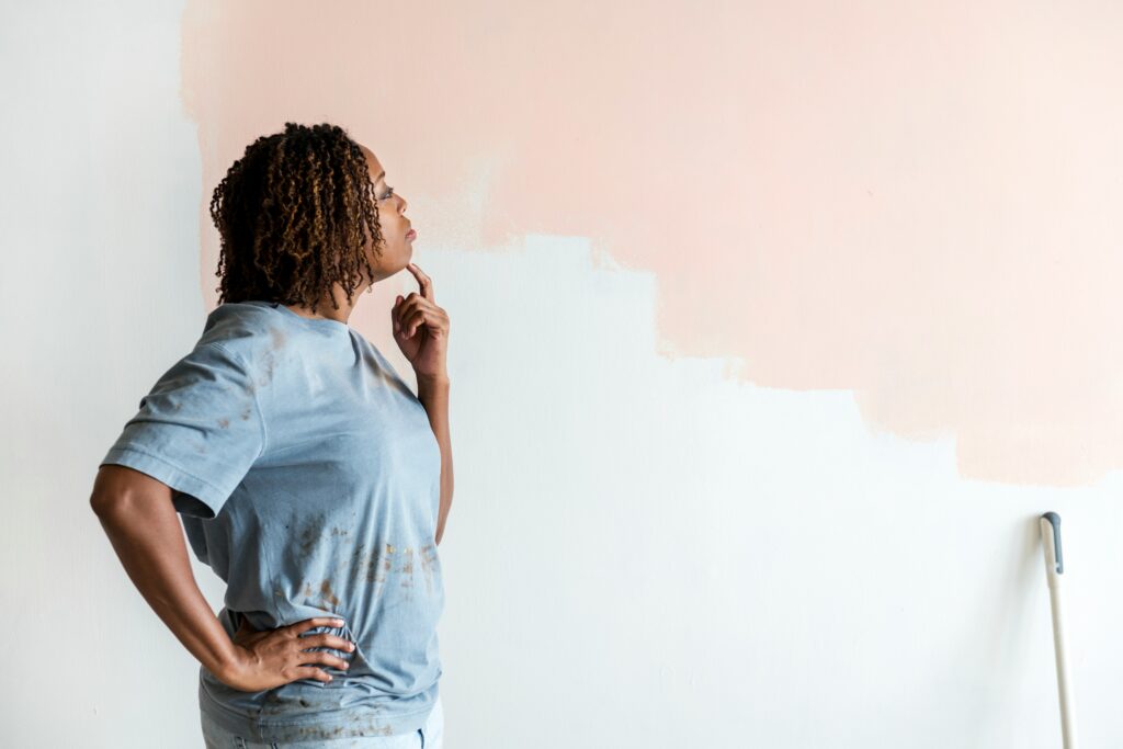 Person checking a paint colour sample on an interior wall
