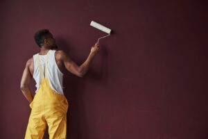 Painter applying a coating to an interior wall with a roller