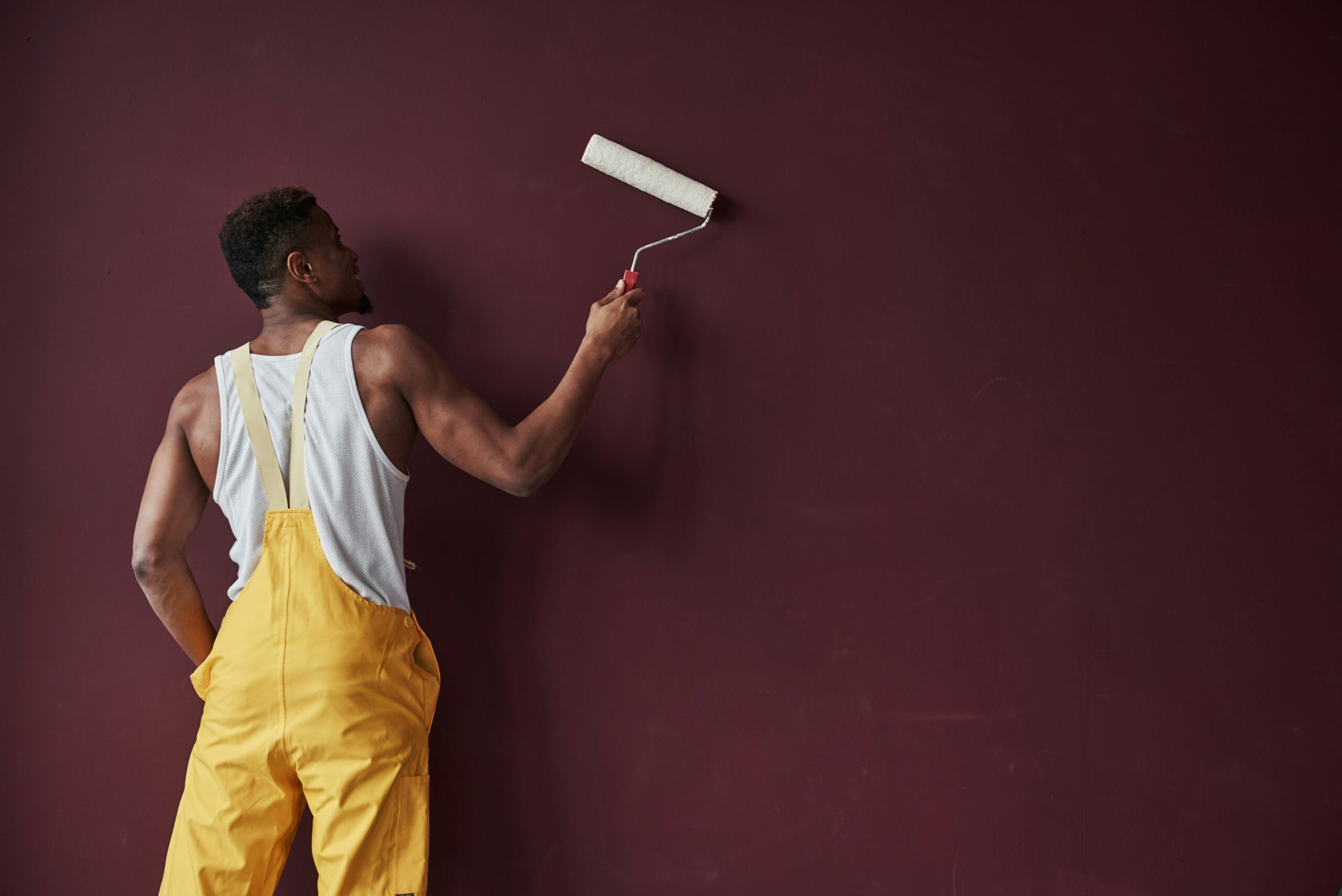 Painter applying a coating to an interior wall with a roller